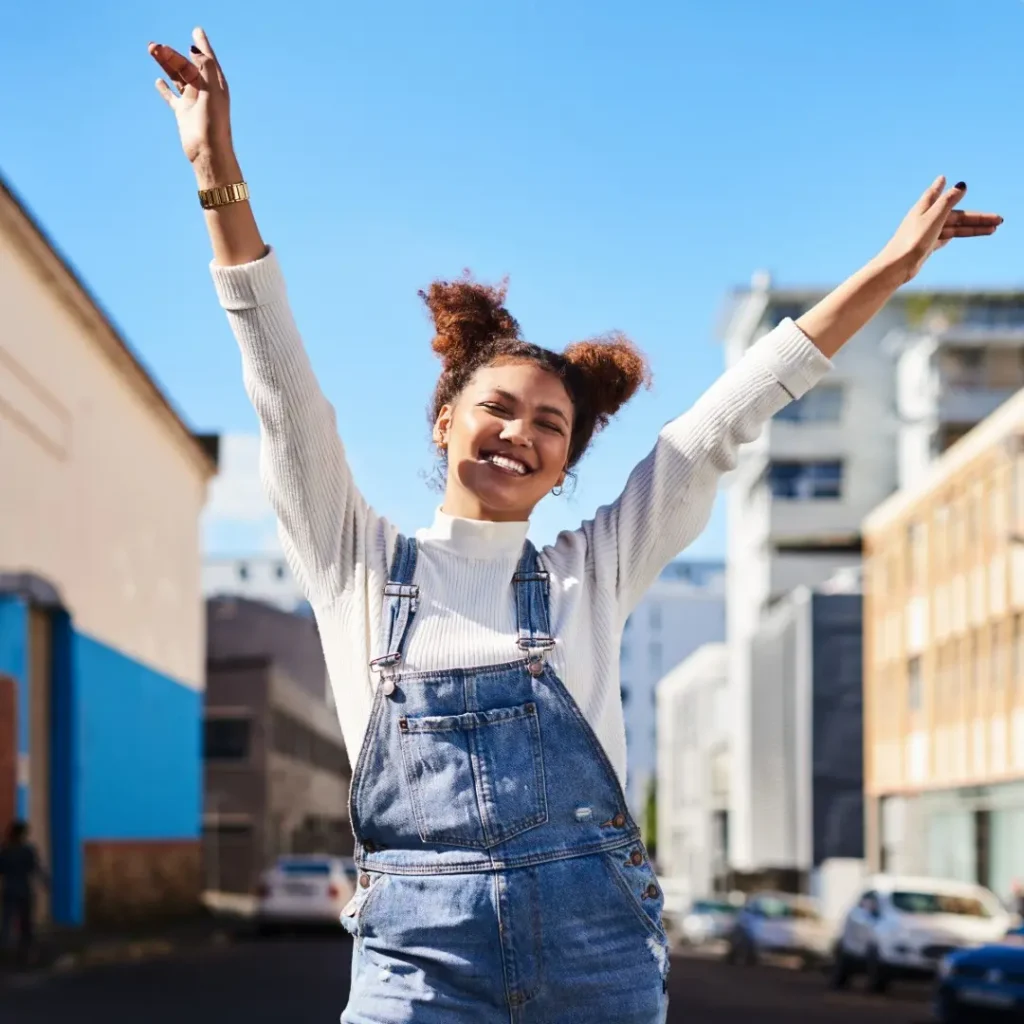 excited woman in overalls with arms raised outdoor 2026 03 25 06 36 03 utc | Voyager Recovery Center
