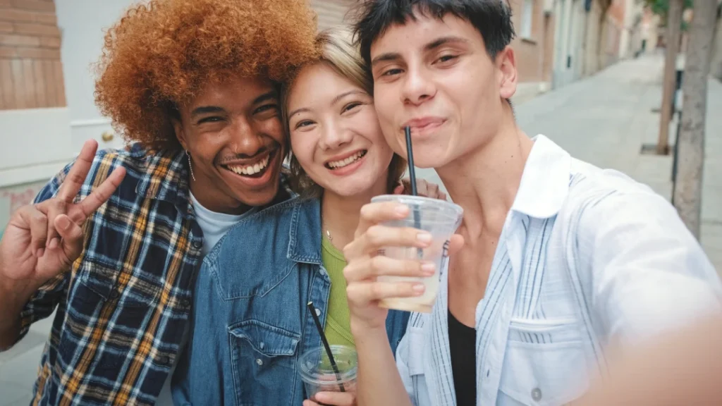 friends smiling and holding iced drinks outside | Voyager Recovery Center