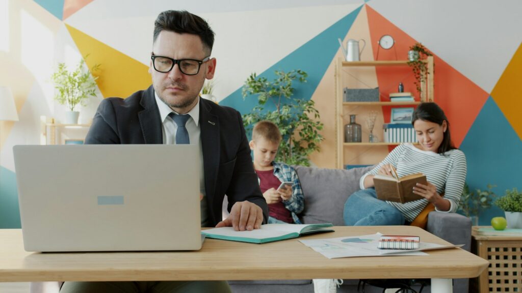 Federal employee reviewing GEHA rehab insurance coverage on a laptop at home with family nearby